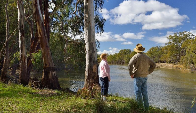 Man and women looking at floodplain on a sunny day