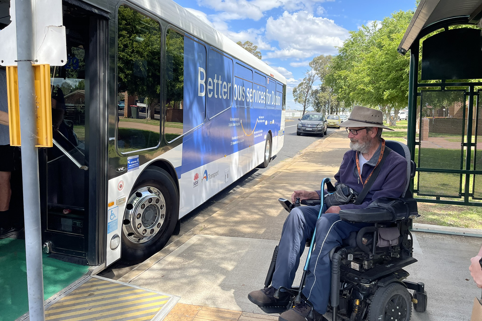 man getting on bus on mobility chair using ramp