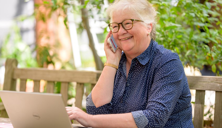 A lady on a mobile phone and laptop