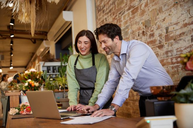 two person looking at at laptop screen