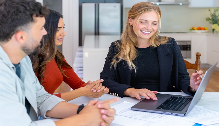 two women and a man is looking at a laptop 