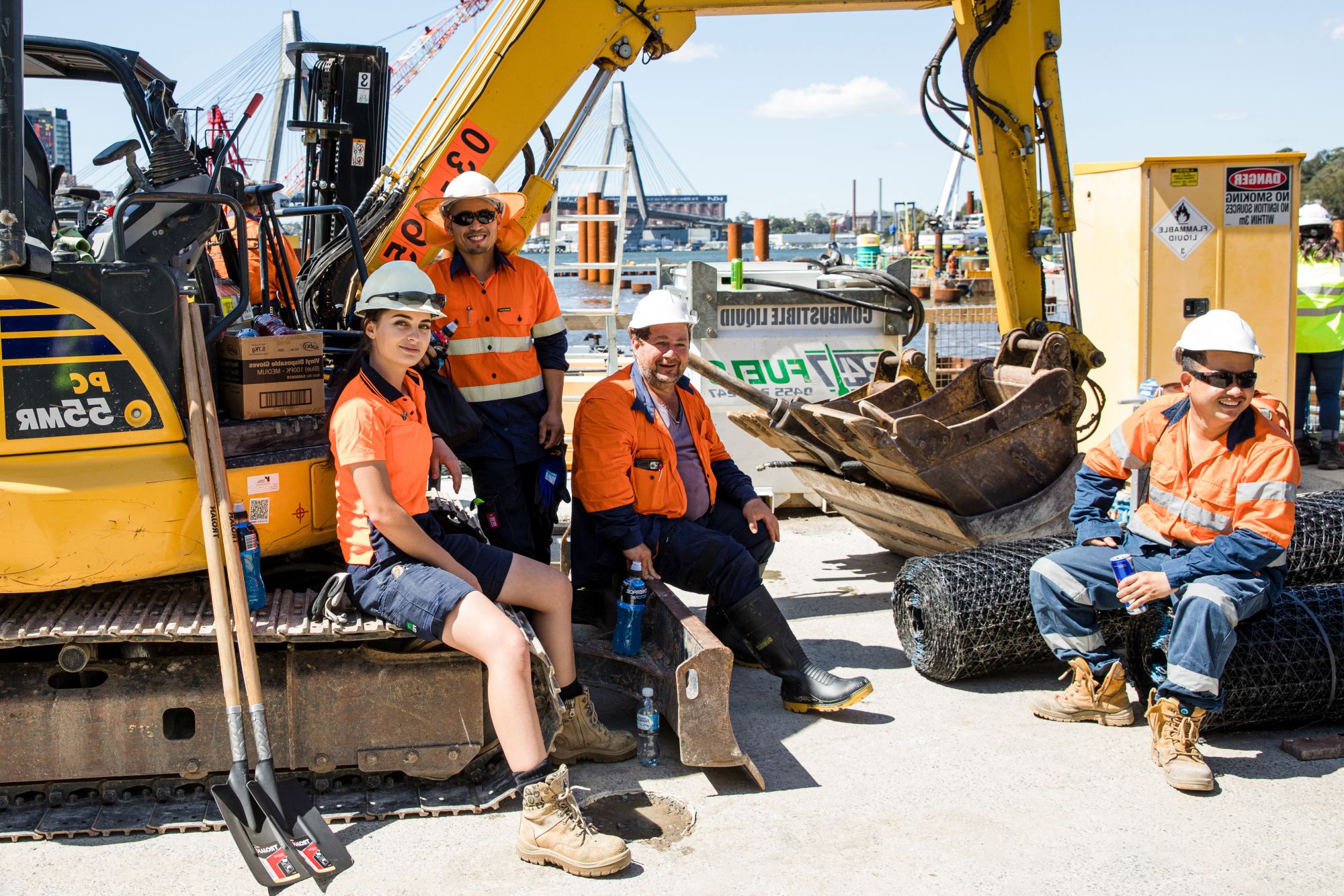 A team of construction workers are standing together around a bulldozer