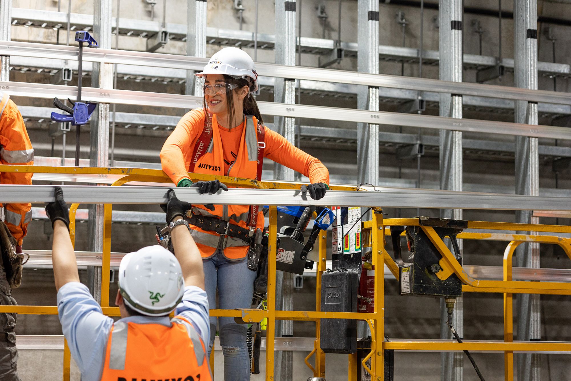 Woman on a construction site wearing hi-vis and wearing a hard hat.