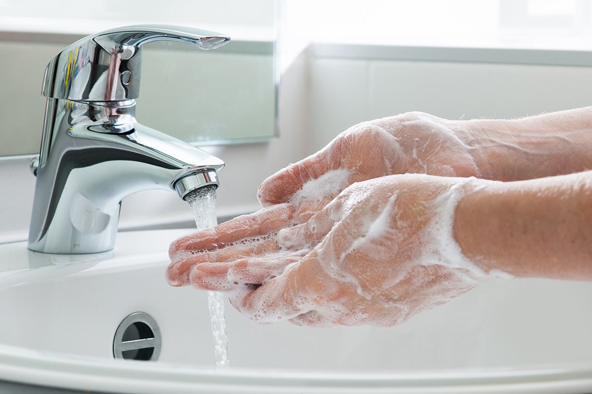 Hands being washed under a tap