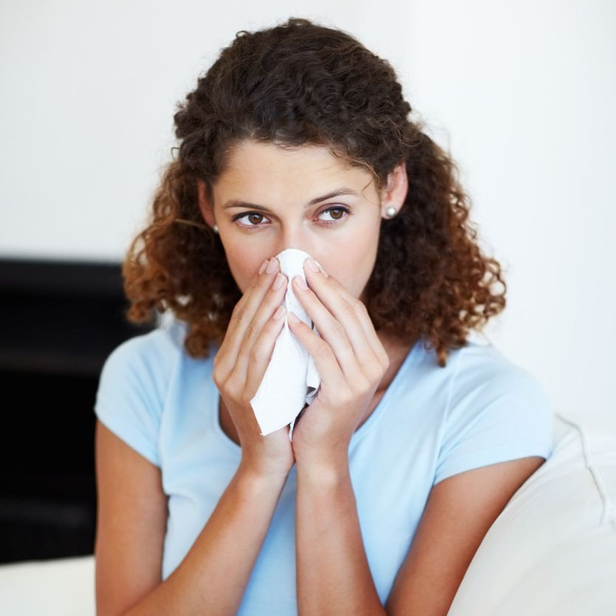 Person blowing nose with a tissue