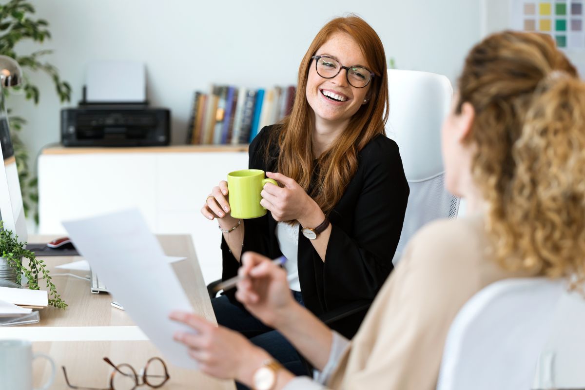 Lady smiling and talking holding coffee cup 