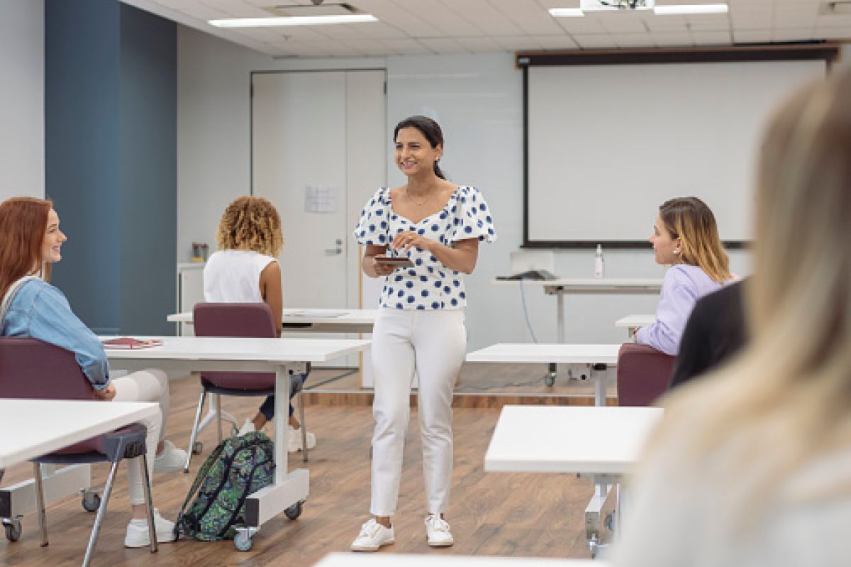 Teacher facing room full of young adult students.