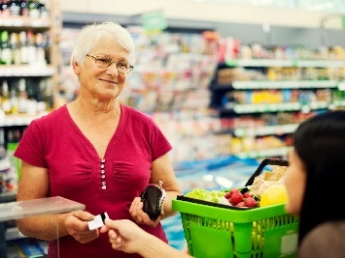 A woman buying a rapid antigen test in a supermarket