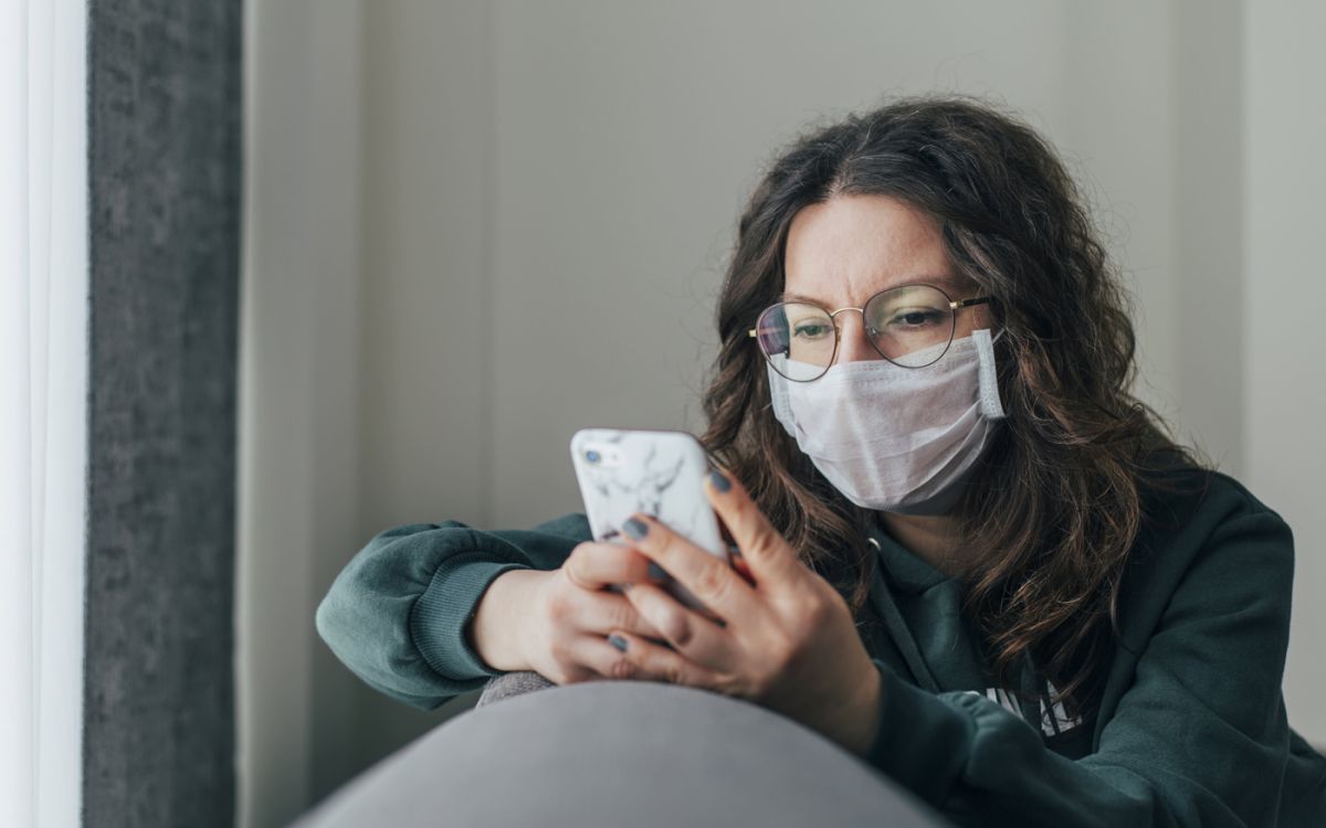 Woman wearing a face mask looking at her mobile phone