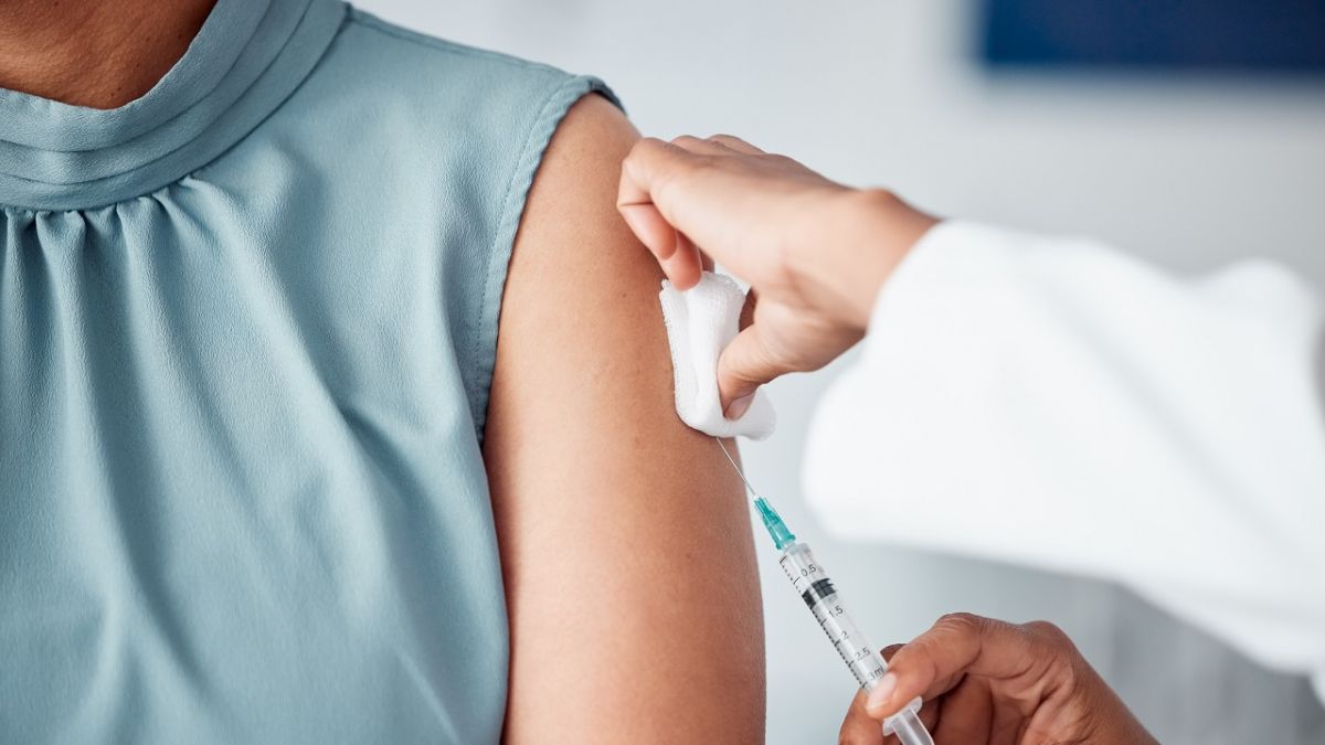 Closeup of a nurse doing a vaccination injection with a needle syringe in a medicare hospital