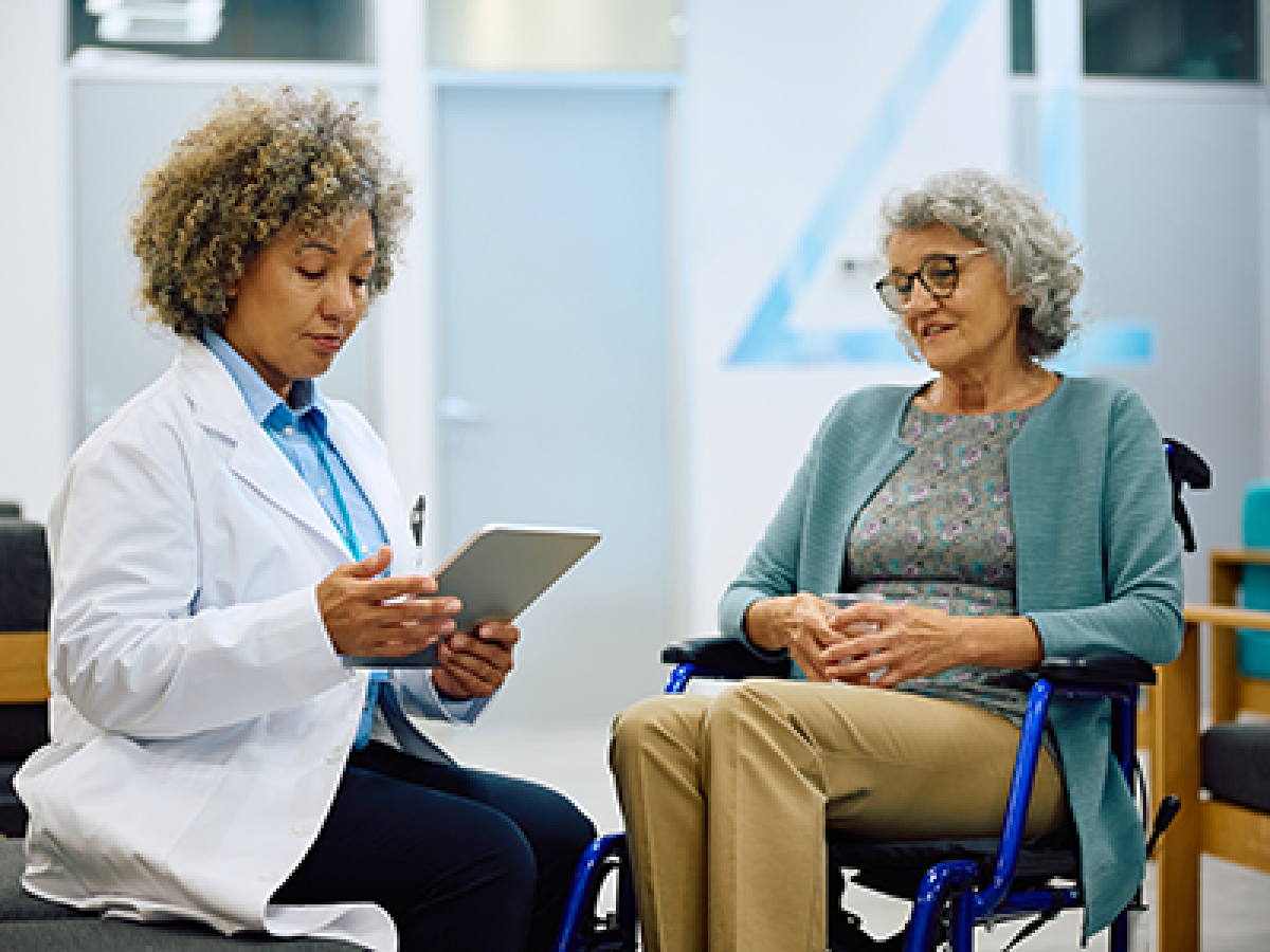 A doctor and patient are sitting in a consult room discussing tools the patient may need.