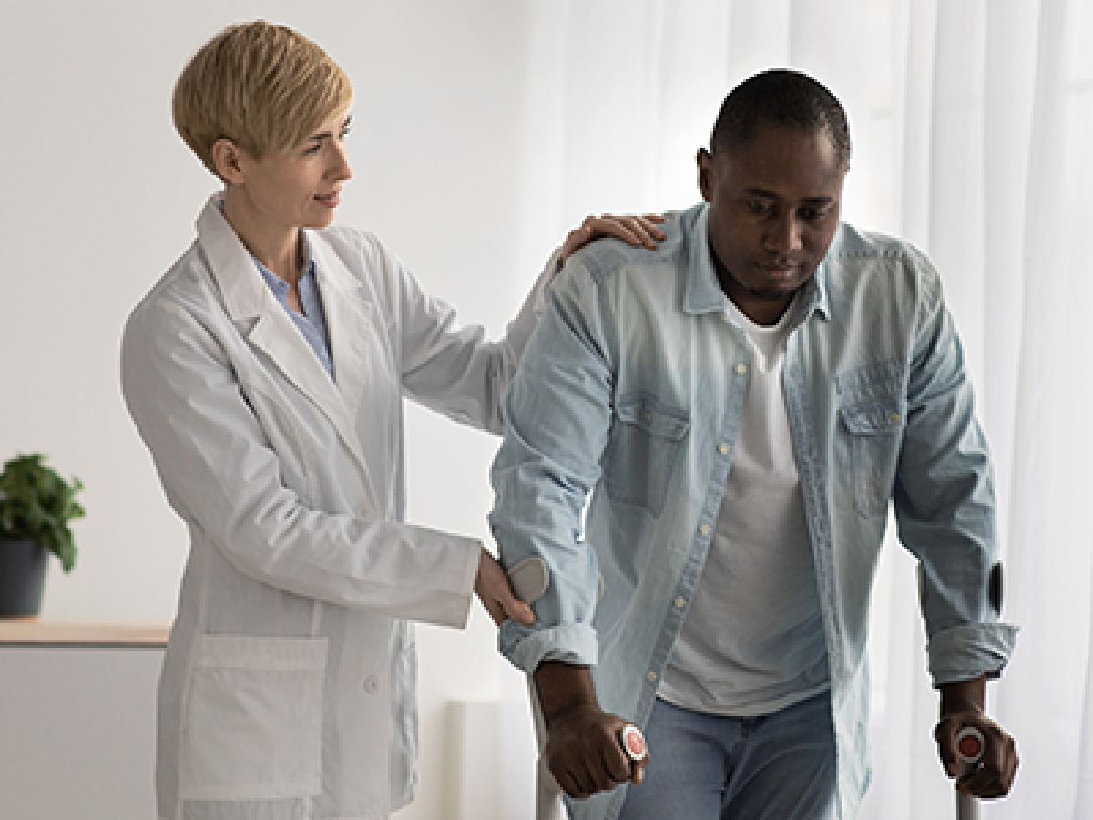 A doctor checking how well a man can walk.