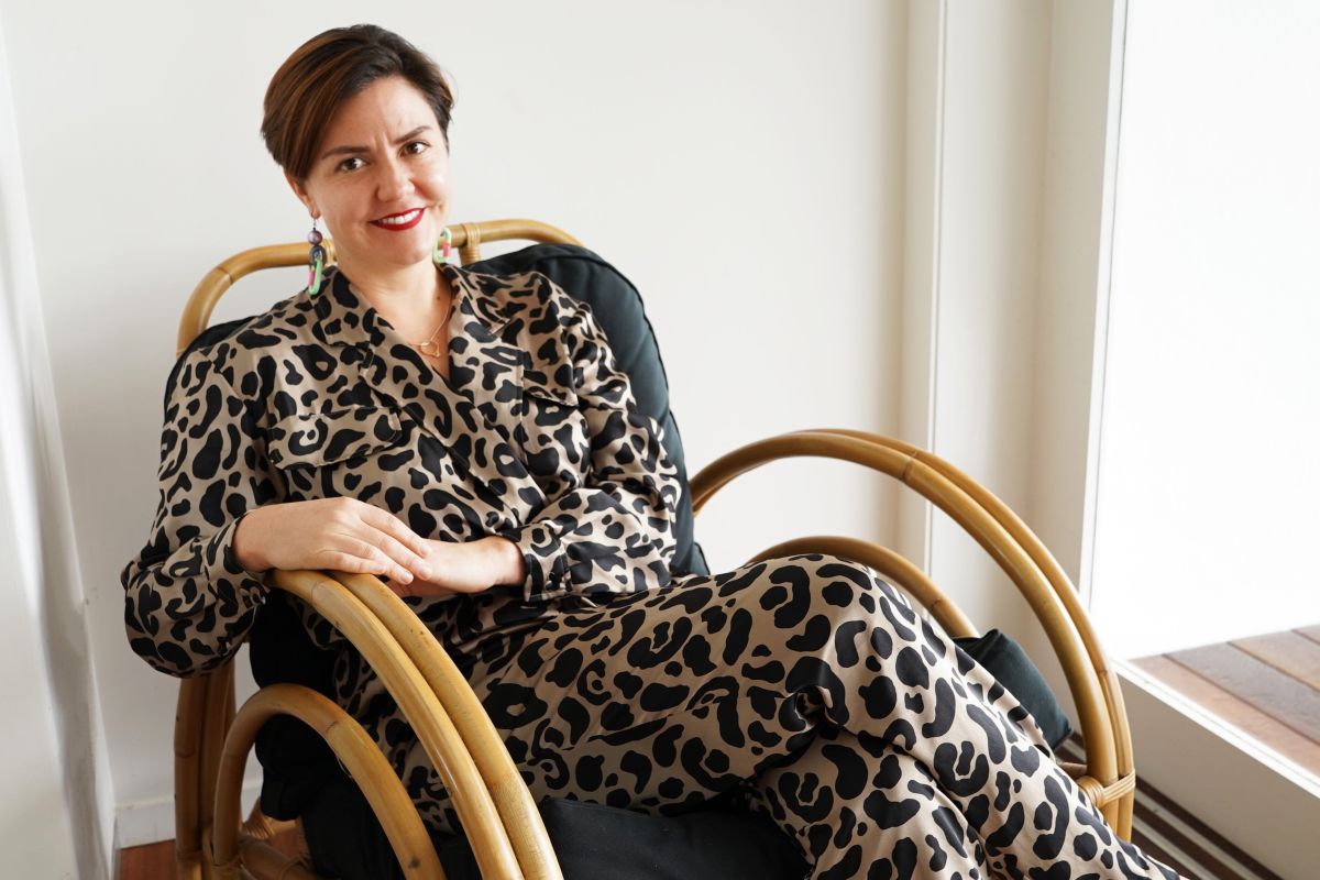 A woman is sitting in a chair and smiling at the camera.