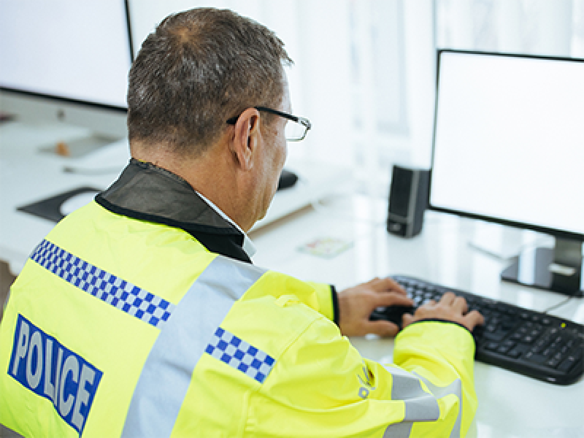 A police officer using a computer.