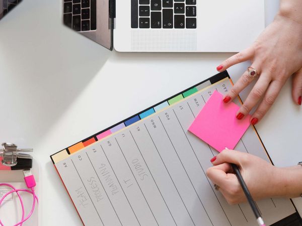 Hands adding notes to a planner