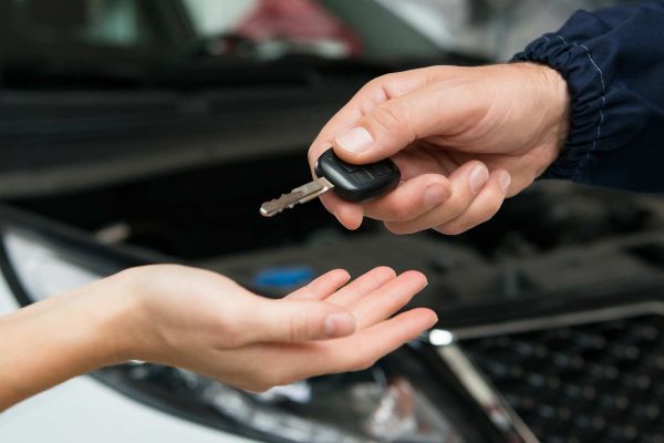 A car key is being given to someone