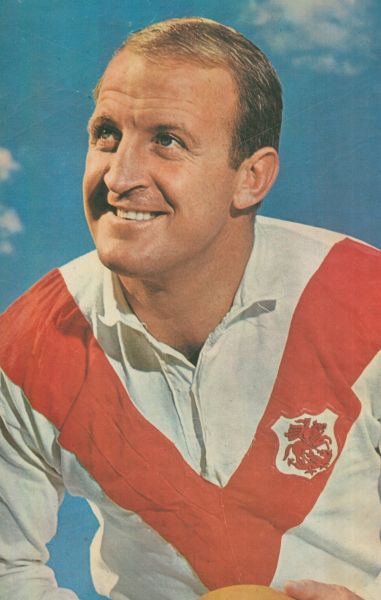 Mr John Raper MBE in 1957 is dressed in a football jersey and shorts posing with a football against a black background.