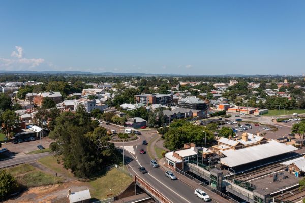 an aerial view of a town with a roundabout, train station, and multi storey buildings