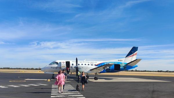 Travellers on the tarmac disembarking from a regional plane