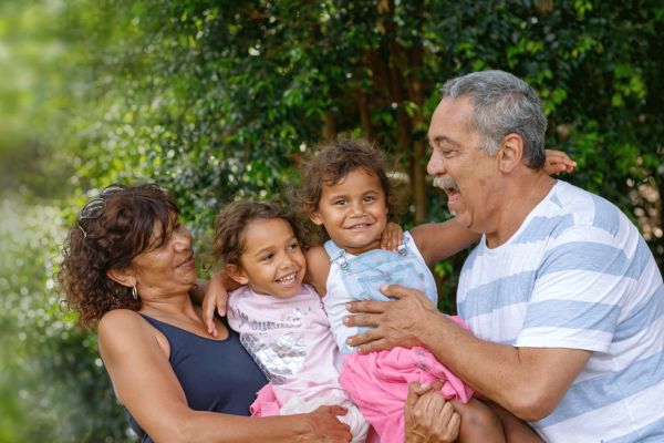 Two young granddaughters with grandparents in the garden happy