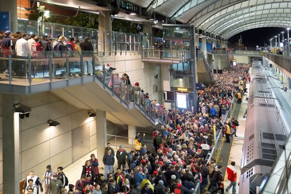 A crowd a people all walking to catch the train at Sydney Olympic Park Station.