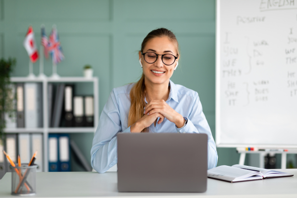 Teacher in front of her laptop, smiling