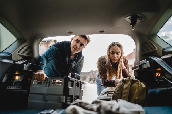 A couple are packing the boot of their car