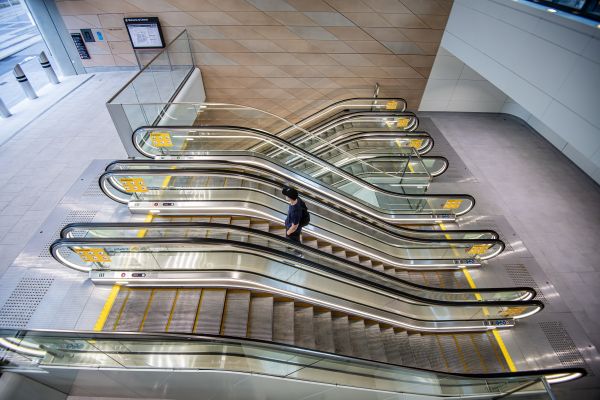 A person on an escalators at a train station.