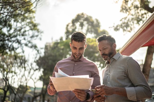 two men looking at planning documents outside