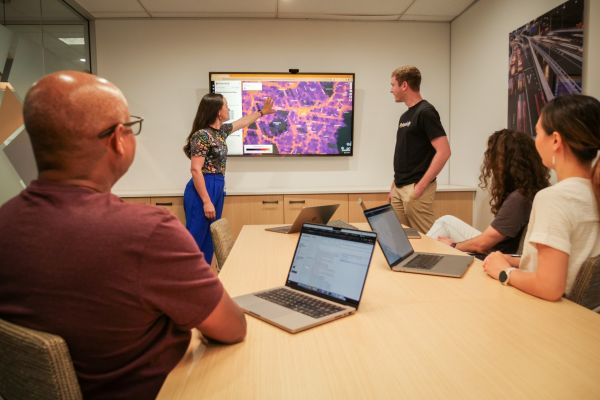 Transport planners in a business meeting viewing spatial data on a large monitor.