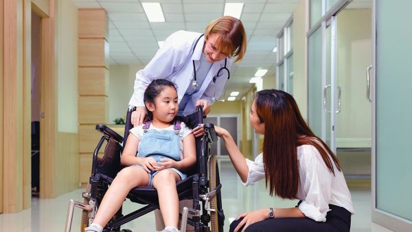 A hospital volunteer with a doctor and patient