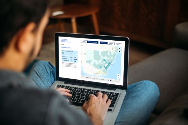 Male sitting cross legged on a couch looking at a laptop showing the Connectivity Index