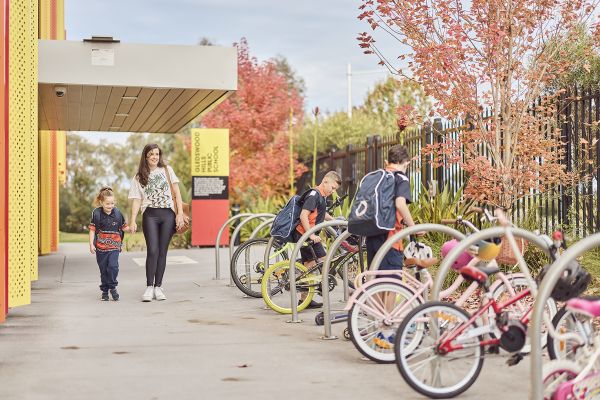 Students add bikes to storage racks at school