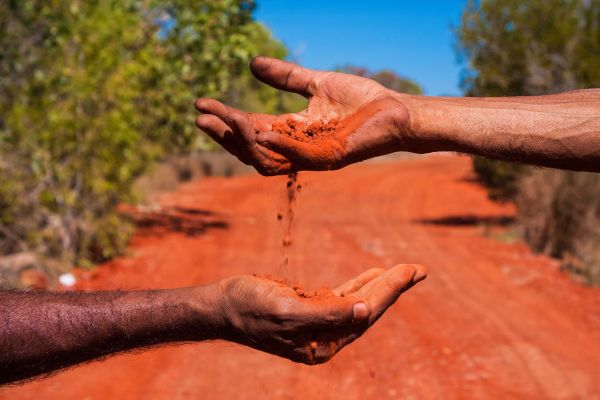 Red sand flowing through hands