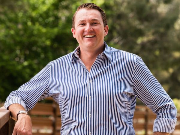 Man standing in a paddock smiling