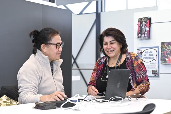 Two women seated at a desk with a laptop, Oran Park Library 