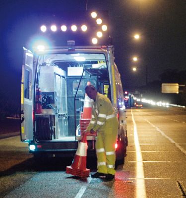 Traffic controller vehicle with temporary arrow illuminated on top pointing which direction to merge.