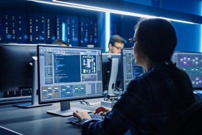 Female cyber security worker using her computer in an office