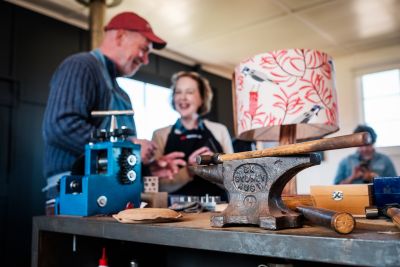 A mature couple talking in their workshop with hand tools in the foreground