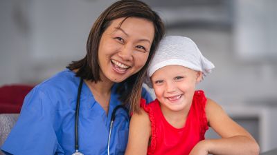 Doctor sits with a child patient who is fighting cancer.