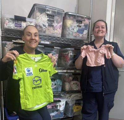 Nurses holding children's clothing items