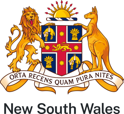 The NSW State Arms in colour which features a kangaroo and lion holding a shield with a sun above it. Below the shield are the words 'Orta recens quam pura nites'. The shield has 4 sections divided by a red cross with a lion in the centre and 4 stars. Within the 4 corners there are 2 with sheep and 2 with bunches of wheat. 