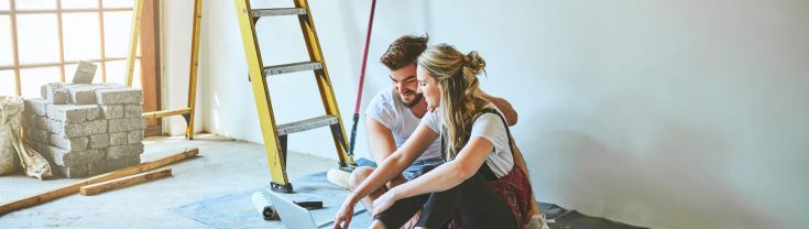 Shot of a young couple using a laptop while busy with renovations at home