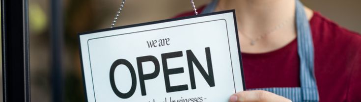 Woman holding an open sign.