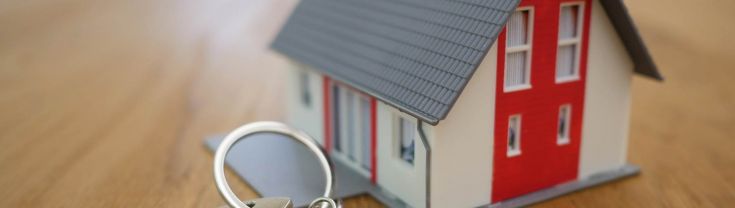 Miniature house on a table with a set of keys