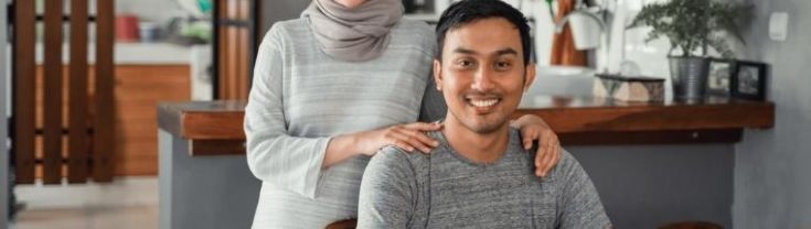 new parents in their dining room with a kitchen in the background