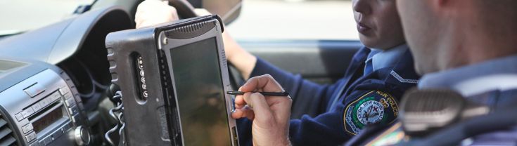 Interior of police car showing mobile radio unit being used by police officers.