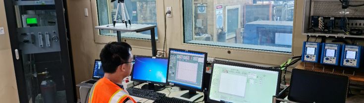 Image of man in high vis testing behind double glazed glass