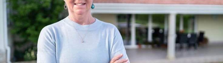 woman in front of house with solar panels