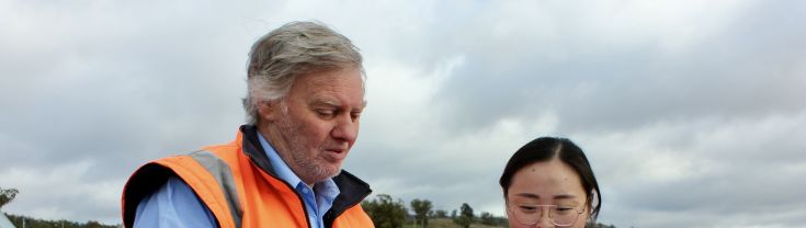 Man and woman inspecting public works plans from field